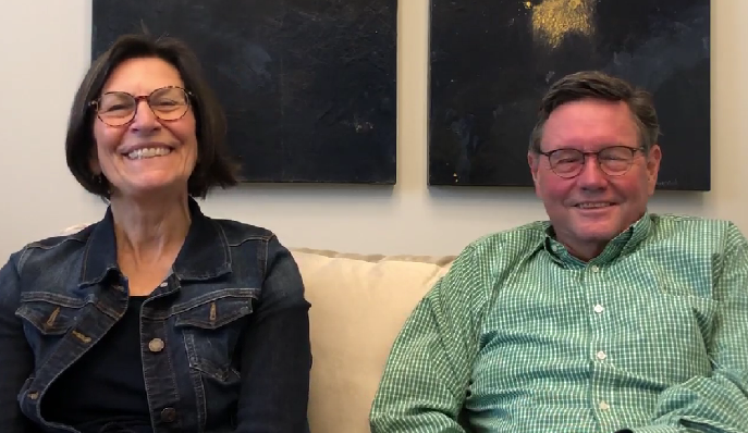 Photograph of Drs. John Howard and Nicole le Riche. Dr. Howard is in a green check shirt and glasses, and Dr. le Riche is in a jean jacket with short dark hair and glasses.